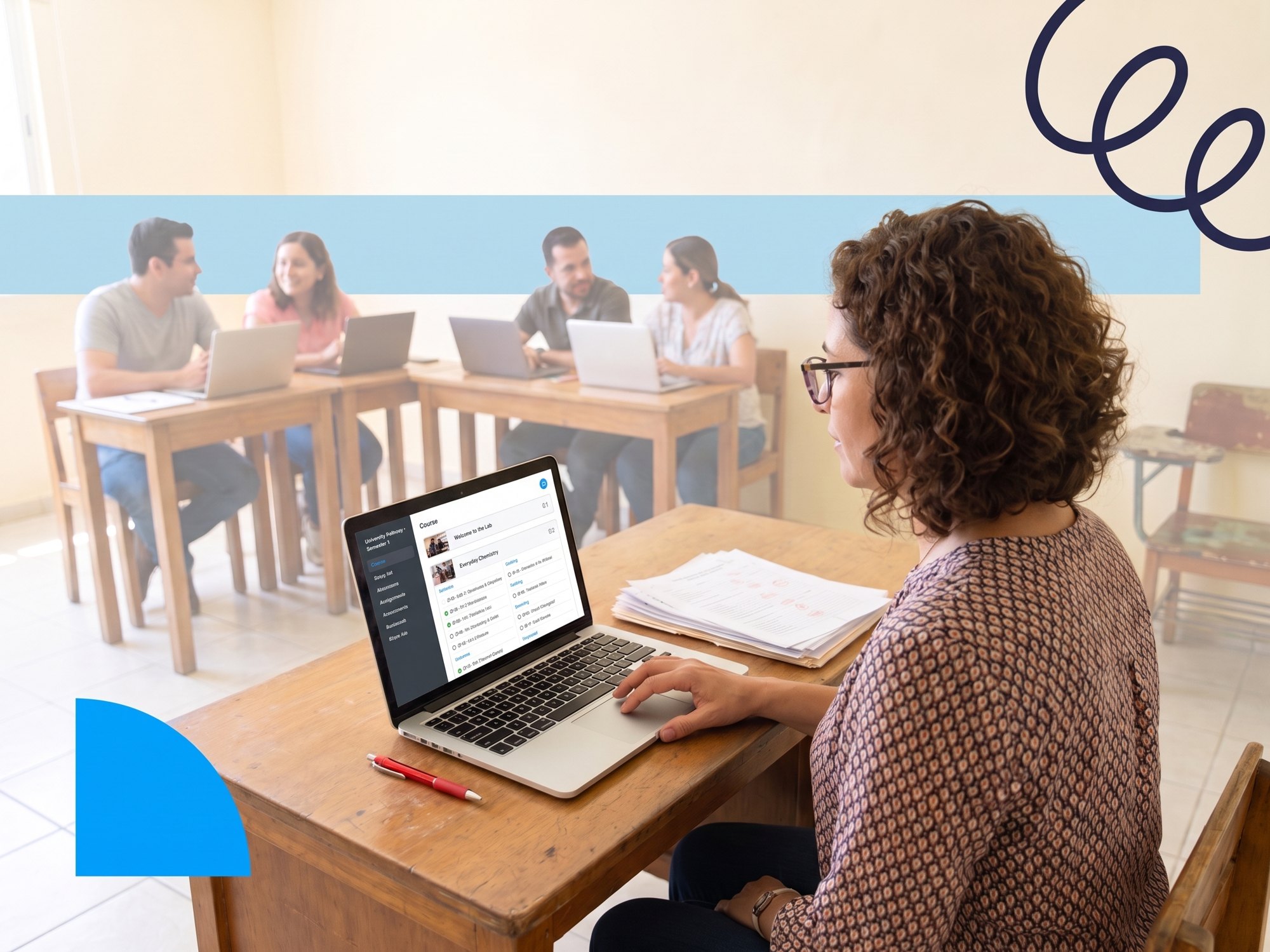 Una docente en un escritorio del aula con una computadora portátil